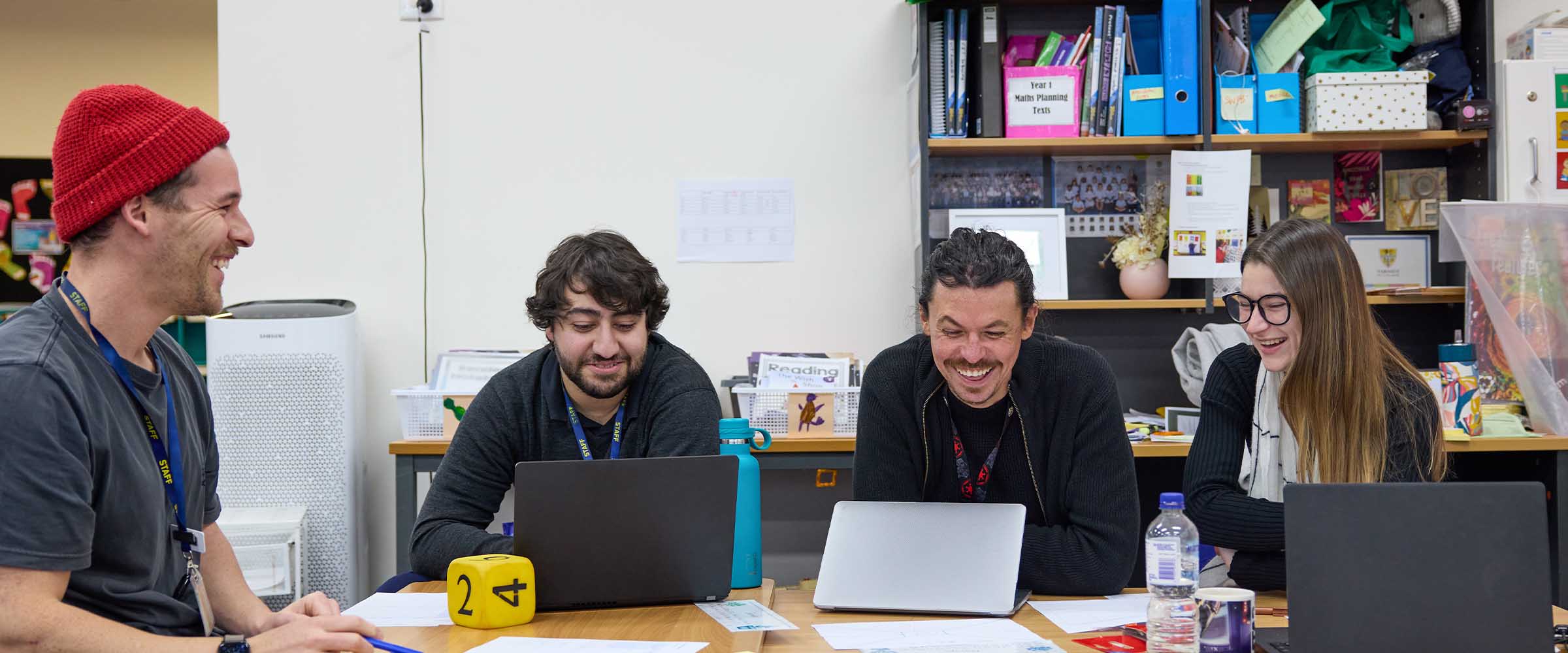 Action Team members examining printed tools to coordinate Be You activities.