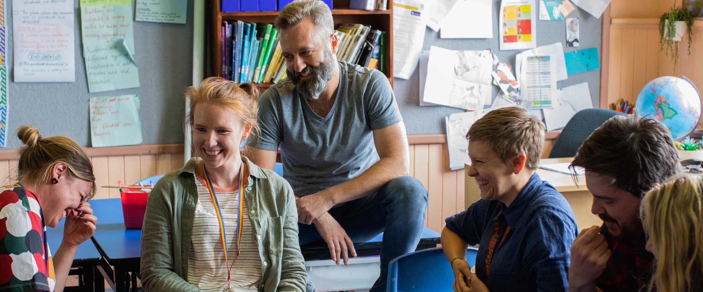 A group of educators sitting around a table and chatting.