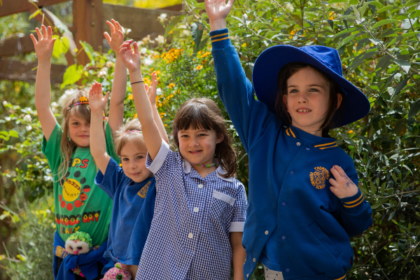 Four children raising their hands to ask a question