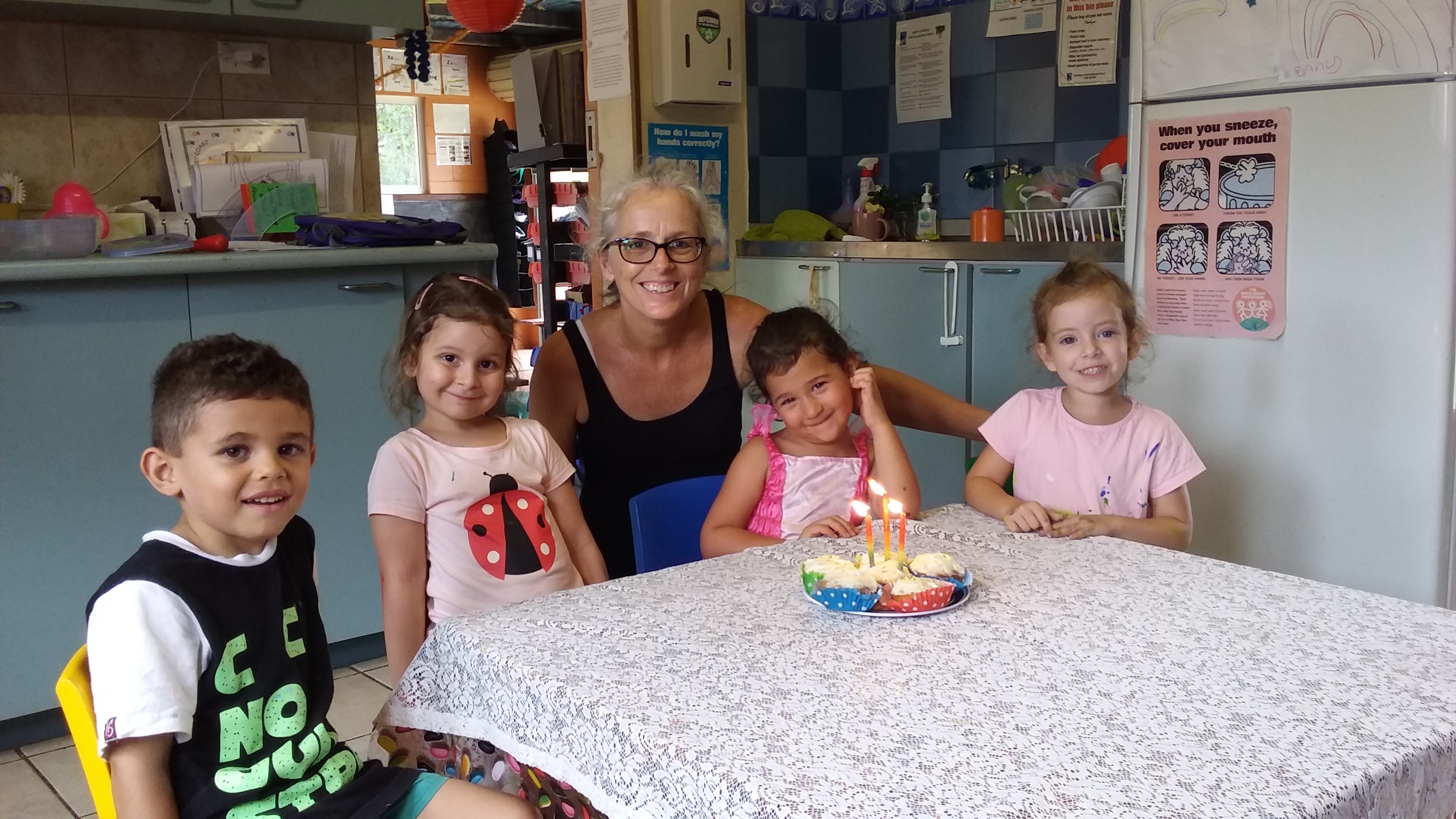 An adult and four children, around a kitchen table