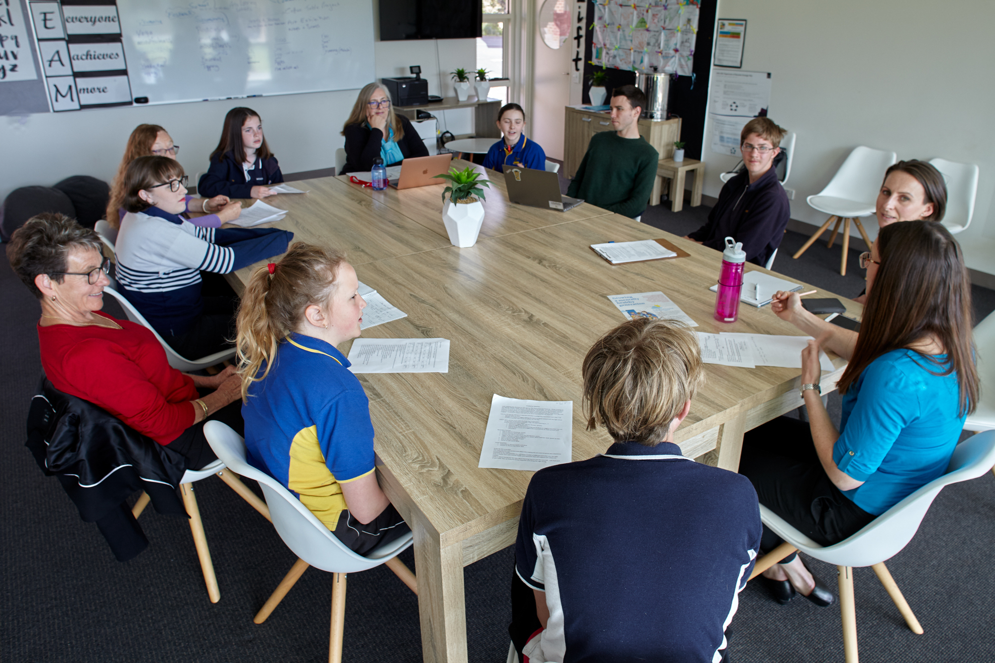 A group of children, sitting around a table with several educators
