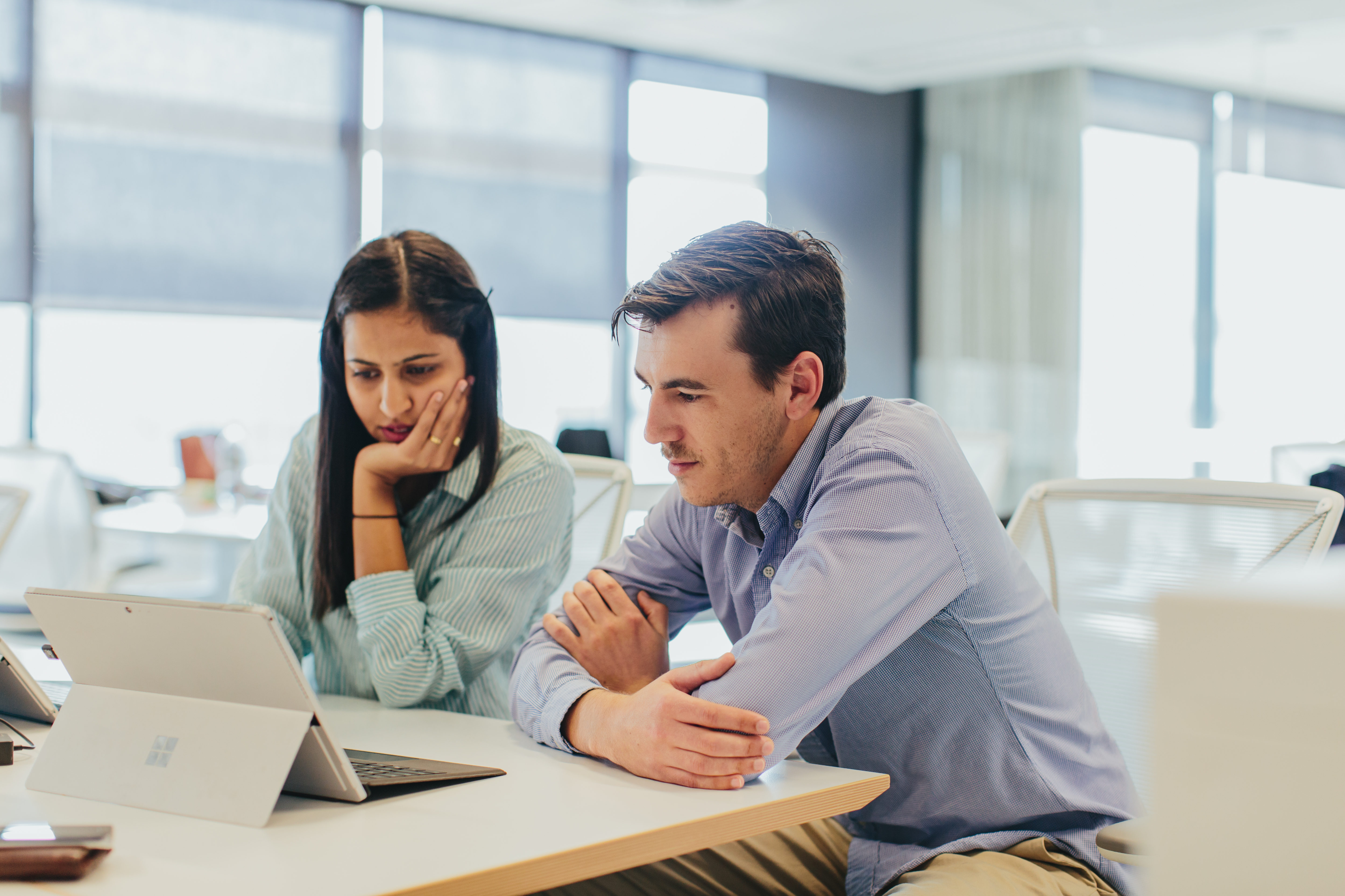 Two adults working at a computer 