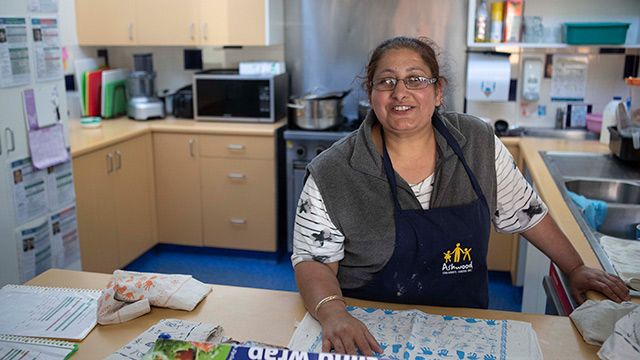 An adult in working in a school kitchen  