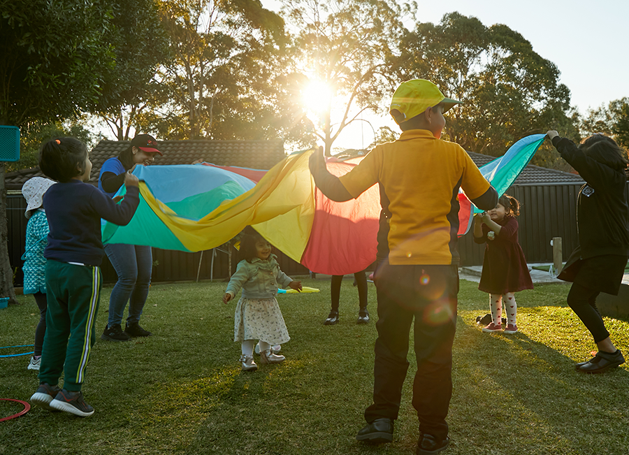 Photo of children playing at early learning service with sun in the sky.