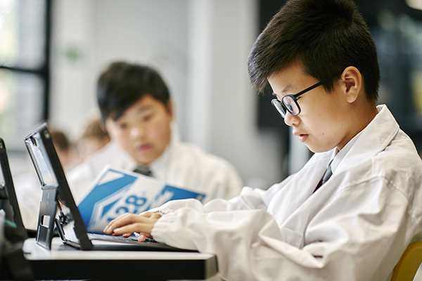 Two young children working on laptops