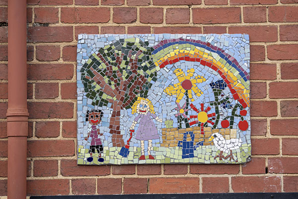 A colourful mosaic on a school wall 