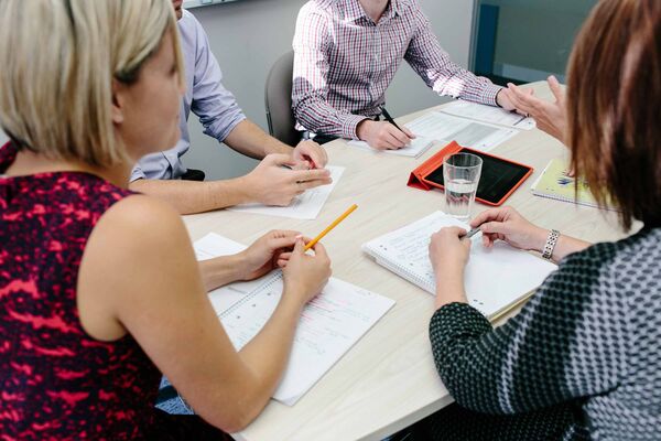 A group of educators sitting around a table, engaged in conversation