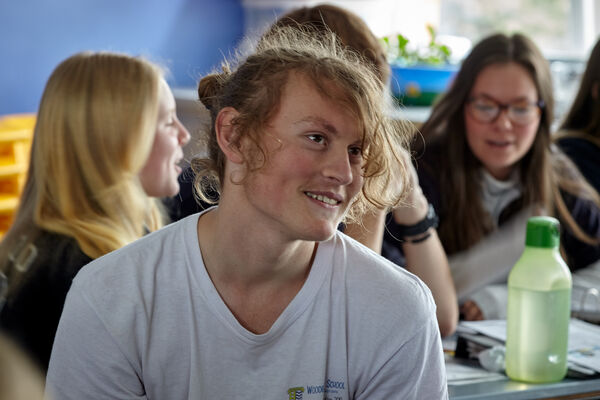 An adolescent in a classroom, smiling