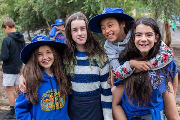 A group of children with their arms around each other 